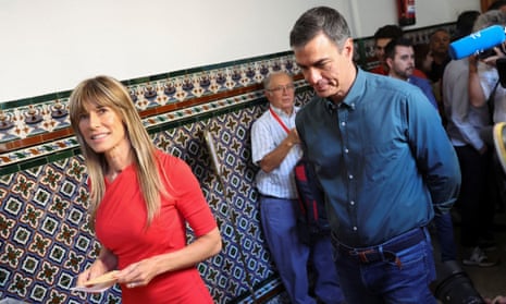 Pedro Sánchez in blue jeans and blue shirt with his wife, Begoña Gómez, in a red dress preparing to vote