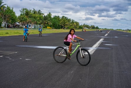 Children ride bikes on the airport runway in Funafuti