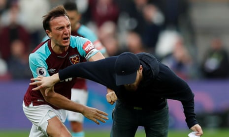 West Ham United’s Mark Noble clashes with a fan who has invaded the pitch in their defeat to Burnley.