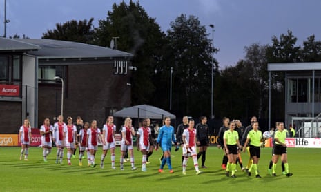 The match officials lead the players out onto the pitch at sports complex De Toekomst.