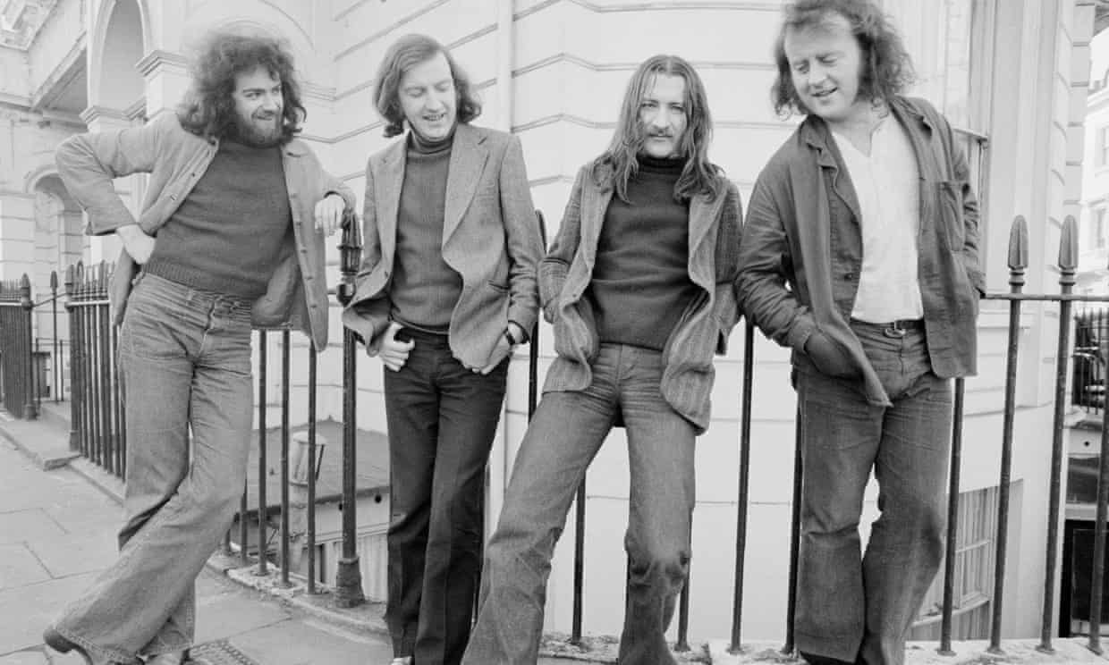 Folk group Planxty, four long-haired men in 1970s jackets, lean against railings outside a building