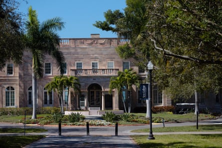 A front view of an admissions building with palm trees in front