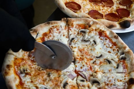 A pizza being cut.