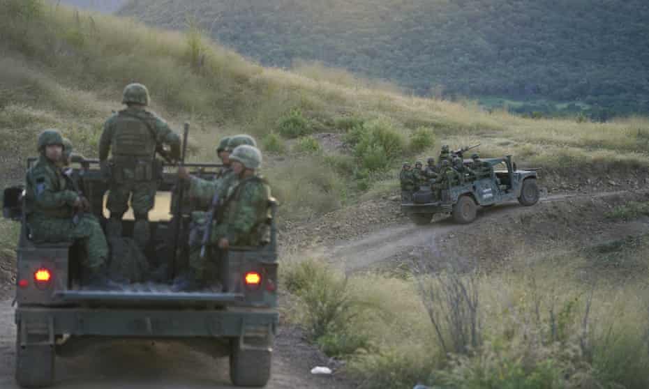 Soldiers patrol near the hamlet Plaza Vieja in the Michoacan state of Mexico. The Mexican army has largely stopped fighting drug cartels here, instead ordering soldiers to guard the dividing lines between gang territories.