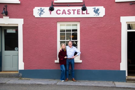 A couple smiling outside the Y Castell pub in Carmarthenshire, Wales