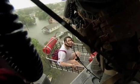 A woman is rescued from flood waters by a US navy helicopter crew in Beaumont.