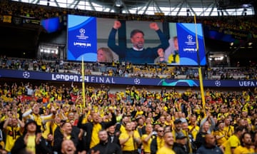 The Borussia Dortmund fans cheer as their former manager Jürgen Klopp is shown on the big screen