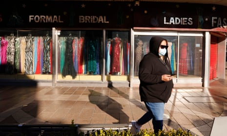A woman is seen outside a closed clothing store in Fairfield in Sydney earlier this month. 