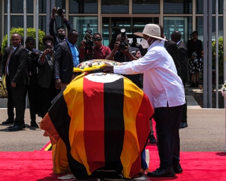 Uganda’s president, Yoweri Museveni, lays a wreath on a casket covered by the Ugandan flag