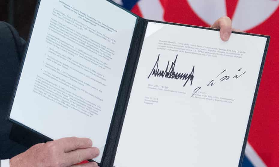 Donald Trump holds up the document signed by him and Kim Jong-un at a ceremony during their historic summit in Singapore.