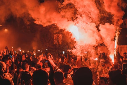 A image of people holding up red flares toward the sky