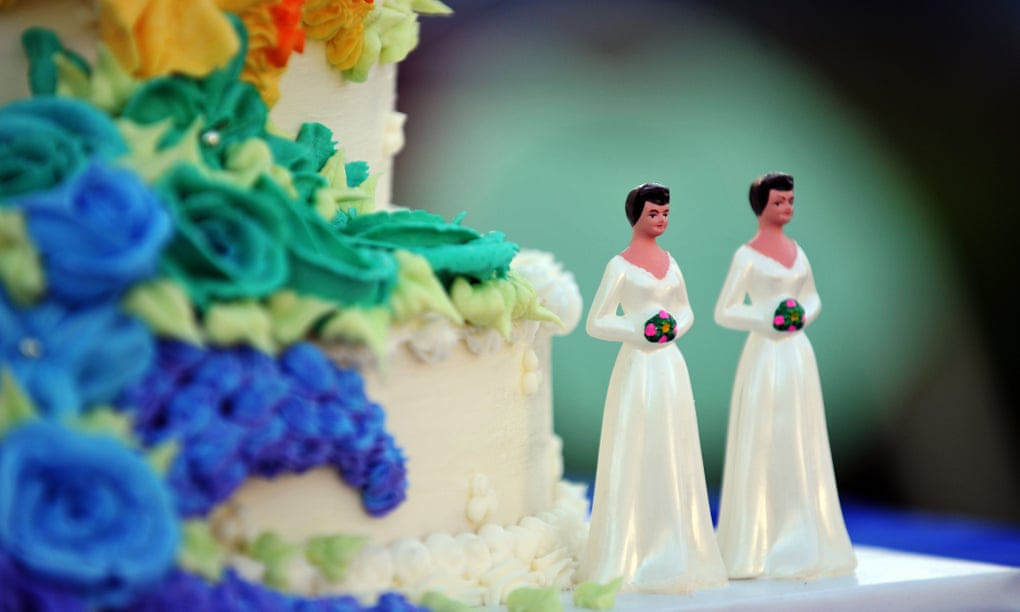 A wedding cake with statuettes of two women