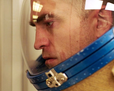 Closeup of Robert Pattinson in space suit and helmet with glass visor