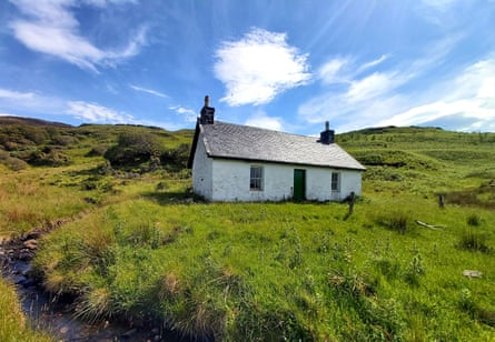 A whitewashed hut on a grassy hillside