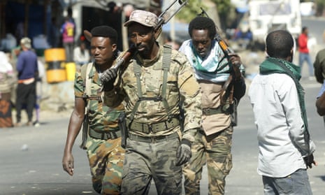 Three soldiers walk down a street in Hayk, Amhara.