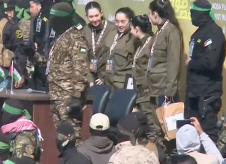 Quatro mulheres reféns israelenses em uniforme militar no palco na Cidade de Gaza.