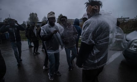 Men in plastic rain-coverings, smiling in terrible weather