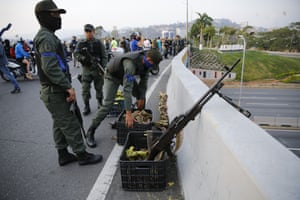 Soldiers take up positions on an overpass next to La Carlota airbase in Caracas
