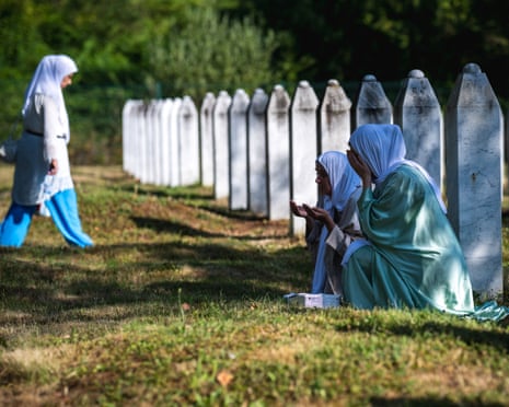 Women pray among the gravestones at the memorial cemetery in the village of Potocari, near the eastern Bosnian town of Srebrenica.