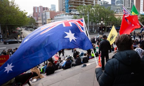 Protesters fly Australian flags on the steps of Parliament House in Melbourne
