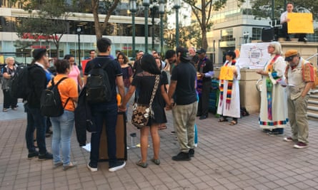 Daca recipients hold hands at a vigil in Oakland.