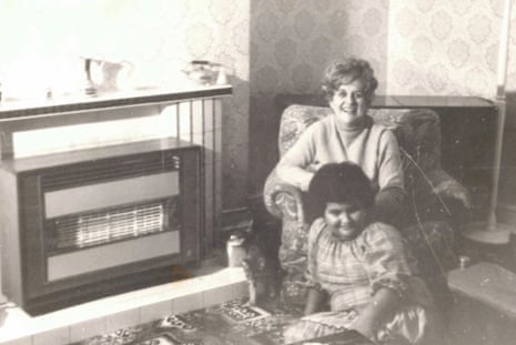 Katy Massey and her mother sitting by a gas fire, with a cat