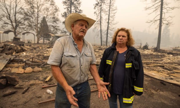 Gary Rainey, a rancher, and the volunteer fire department chief, Janet Jones, talk to a reporter at the ruins of the century-old Klamath River Community Hall, which was destroyed by the McKinney fire.
