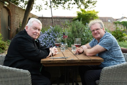 Don and David sitting at an outside restaurant table, smiling at the camera