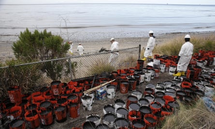 Plastic buckets with oil collected from the beach are placed at the side at Refugio state beach.
