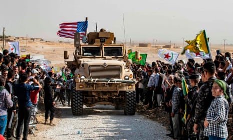 Syrian Kurds gather round a US armoured vehicle