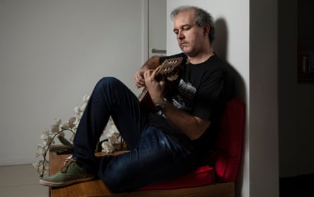 Edu Krieger sits playing a guitar