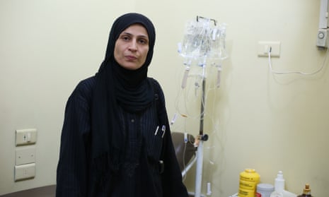 Syrian female medic, Umm Abdu, stands in front of medical equipment