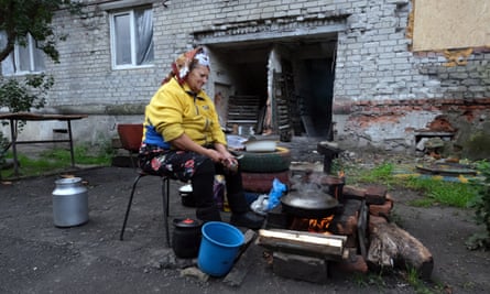 Olena Grigorivna cooks spaghetti outside her apartment