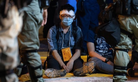 Detained and injured protesters wait to be evacuated by ambulance near Polytechnic University of Hong Kong in 2019.