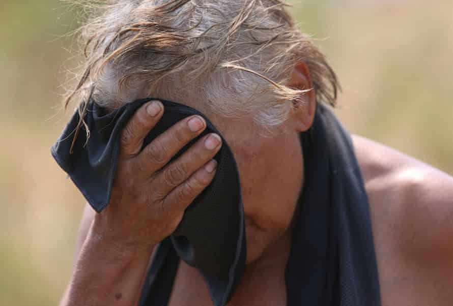 Darlene Salgado, 65, presses an ice cold cloth to her forehead. Coordinators from the Arches Project handed out water and cold cloths to people during a heatwave in Salem, Oregon, on Thursday.