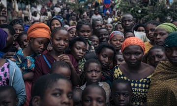 Dozens of war-displaced people stand in the courtyard of an elementary school where they have taken refuge in Minova, South Kivu province, in the East of the Democratic Republic of Congo