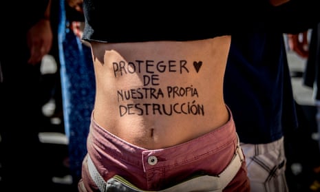 An activist shows her belly, painted with the words, “to protect from our own destruction” during a protest called by the “Fridays For Future” movement on a global day of student protests aiming to spark world leaders into action on climate change on March 15, 2019 in Santiago, Chile.