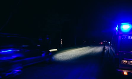 A makeshift ambulance drives at night with its blue siren light