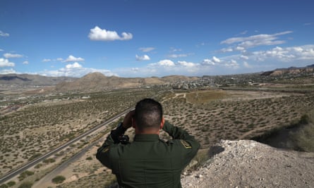 An agent scans the US-Mexico border at Sunland Park, New Mexico ... many thousands of migrants have perished in hostile terrain.