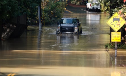 Truck drives through flood water on a road in Guerneville, California.