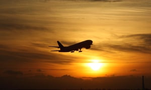 A plane taking off from Heathrow at sunset