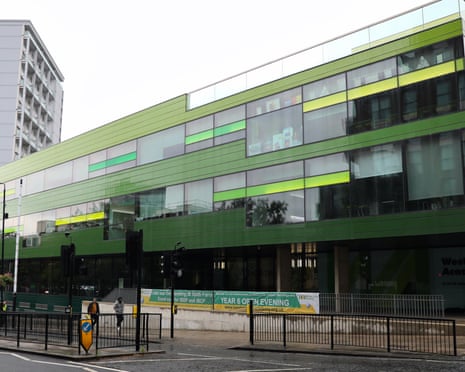 A street view of Westminster academy, a long low modern glass and green-panelled building