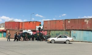 Afghan police use shipping containers to block the road.
