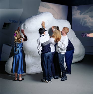 Five children place their hands on the sculpture The Iceberg 2020