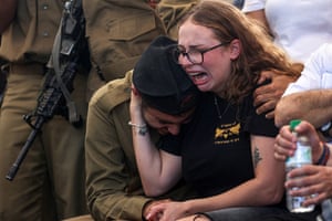 A woman crying and embracing a soldier at a funeral in Beit Shean, Israel.