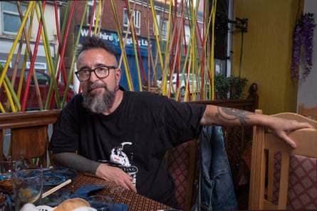 Man with long beard and glasses sitting at a restaurant table