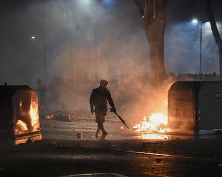 Burning rubbish containers during clashes with police after a march in support of a left-wing social centre that was evicted by authorities in Turin in January 2026.