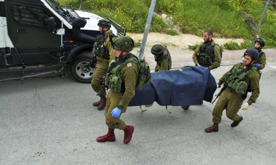 Israeli soldiers carry the body of a Palestinian in the West Bank city of Hebron last week.