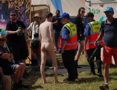 The man who streaked during Max Richter’s performance is led away from the stage.