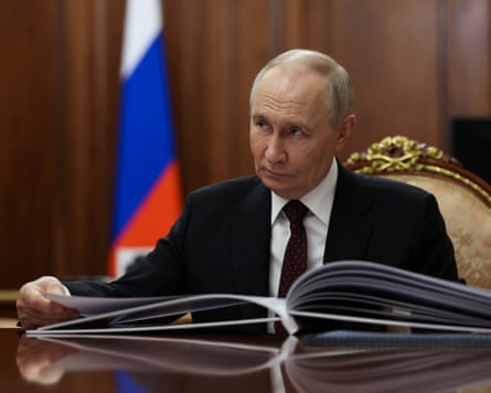 Vladimir Putin meets a regional governor in Moscow on Monday.